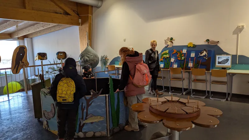 Kinder erkunden interaktive Stationen im Wildpark, um mehr über Tiere zu lernen.